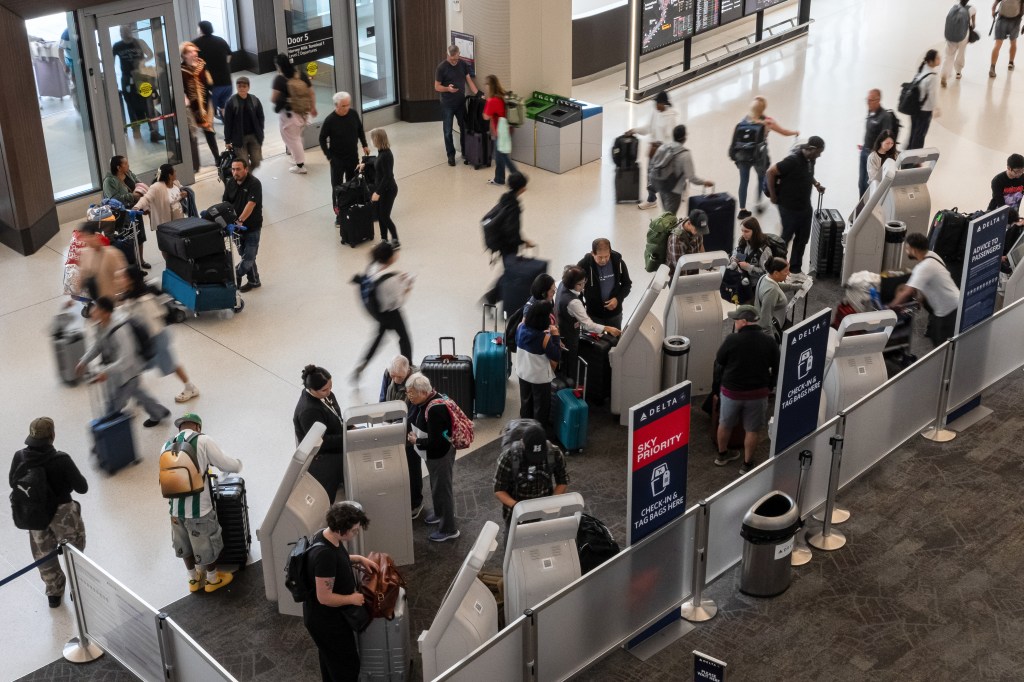 Travelers use self-service kiosks in the Delta check-in area at San Francisco International Airport (SFO).