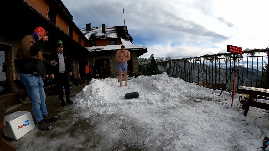 Damian Kasprzyk, in shorts, standing barefoot in a pile of snow to set a record for longest time in full body contact with snow.