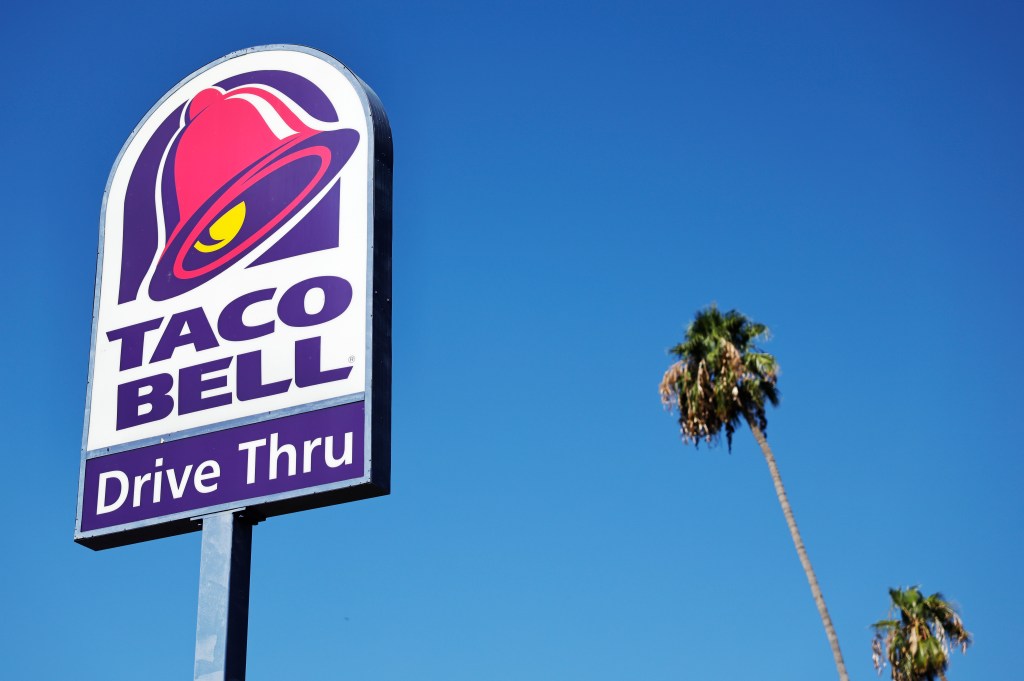 Taco Bell drive-thru sign with a palm tree in the background.