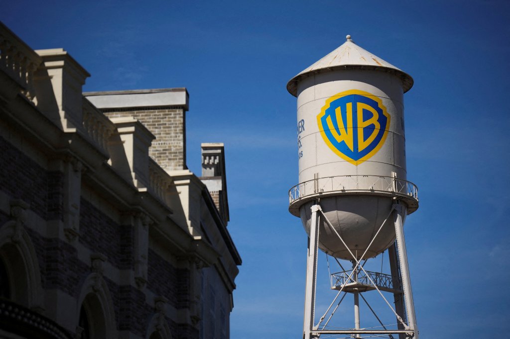 The Warner Bros. Water Tower with the yellow and blue WB logo against a clear blue sky.