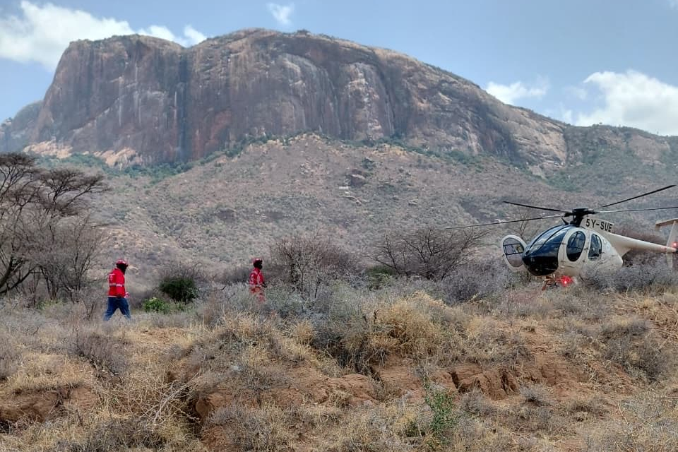 Kenya Red Cross teams and a helicopter during a rescue and recovery operation near Mt. Ololokwe.