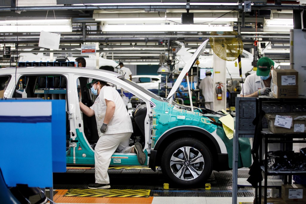Employees work on the Honda CR-V vehicle on an assembly line at Honda Canada Manufacturing.