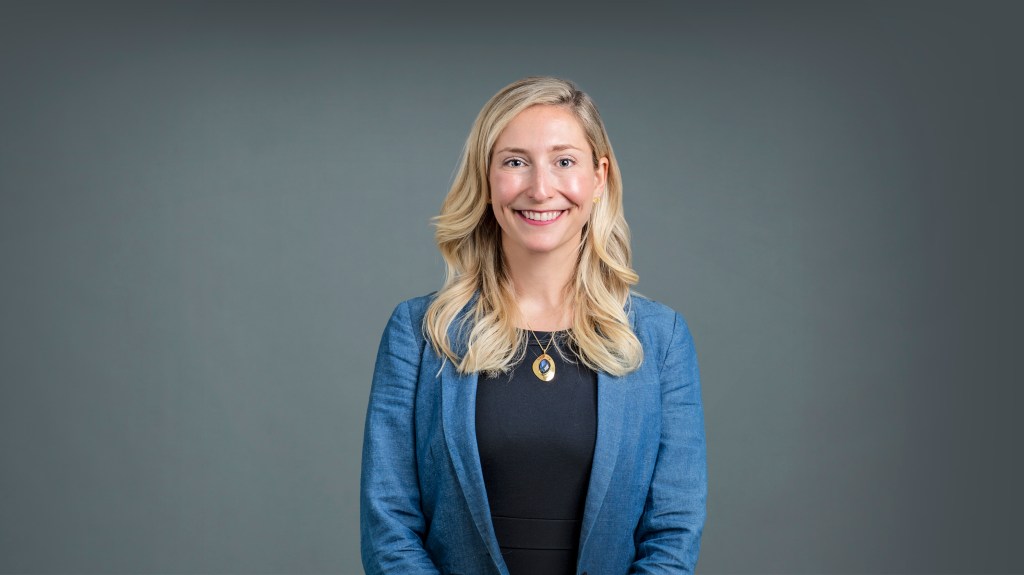 Katherine M. Ort smiling, wearing a black top and a blue blazer.