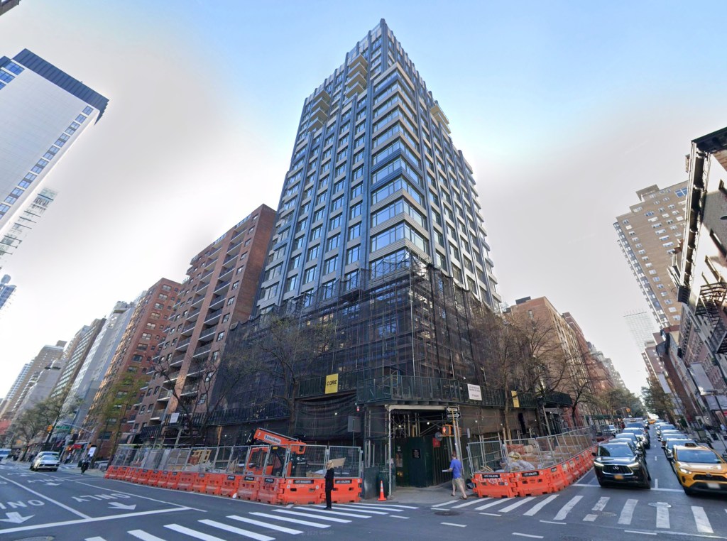 A view of 540 Third Ave. in New York City, a tall building with scaffolding around its lower levels, surrounded by other city buildings and a street with cars and construction barriers.