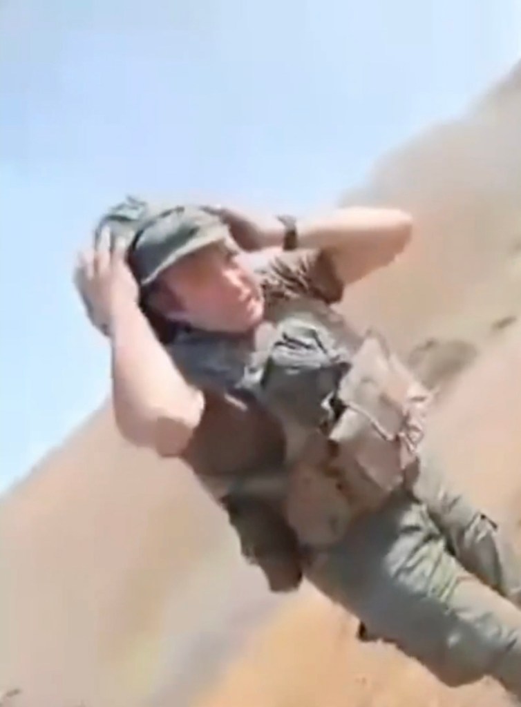 A Russian trainee recoiling in shock after firing an RPG too close to himself, with smoke and debris rising around him.