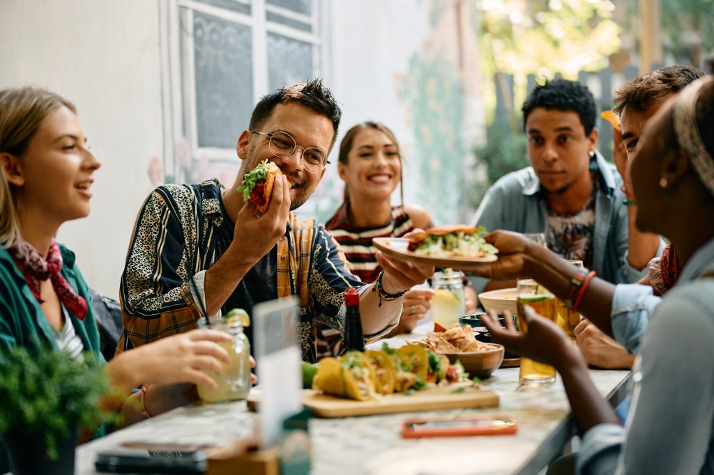 Young happy people having lunch together in a Mexican restaurant.