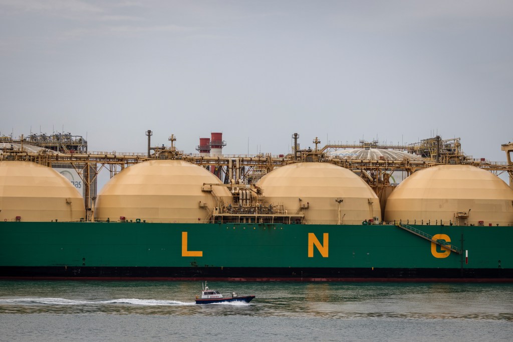 Liquefied natural gas (LNG) tanker LNG River Niger in the port of Barcelona, Spain, with a small boat passing by.