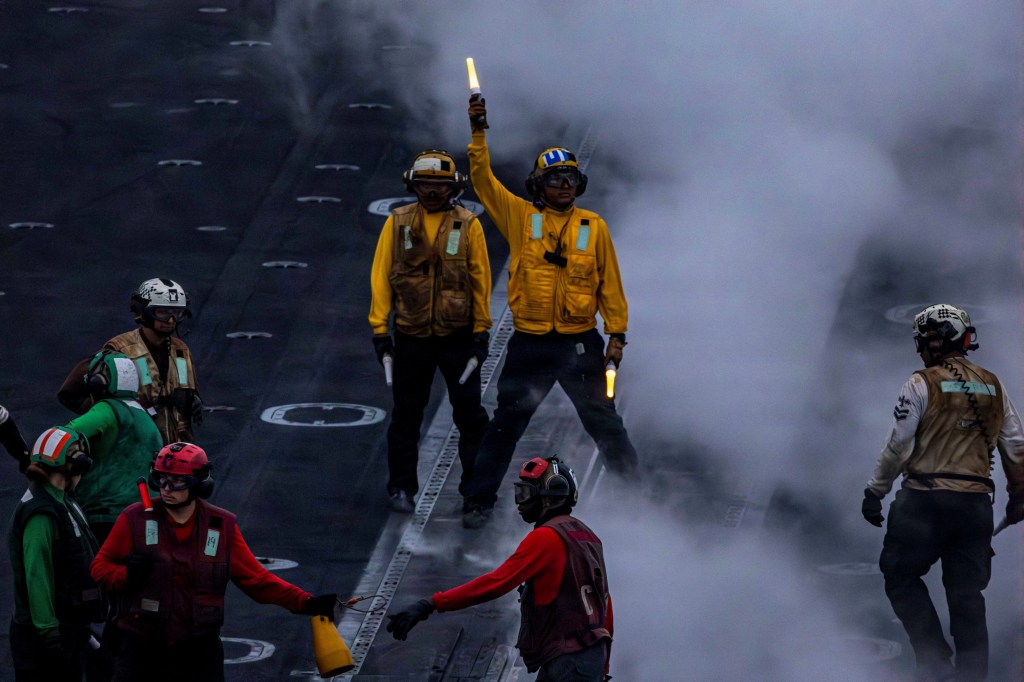 U.S. Navy sailor directs aircraft on the flight deck of the Nimitz-class aircraft carrier USS Abraham Lincoln.