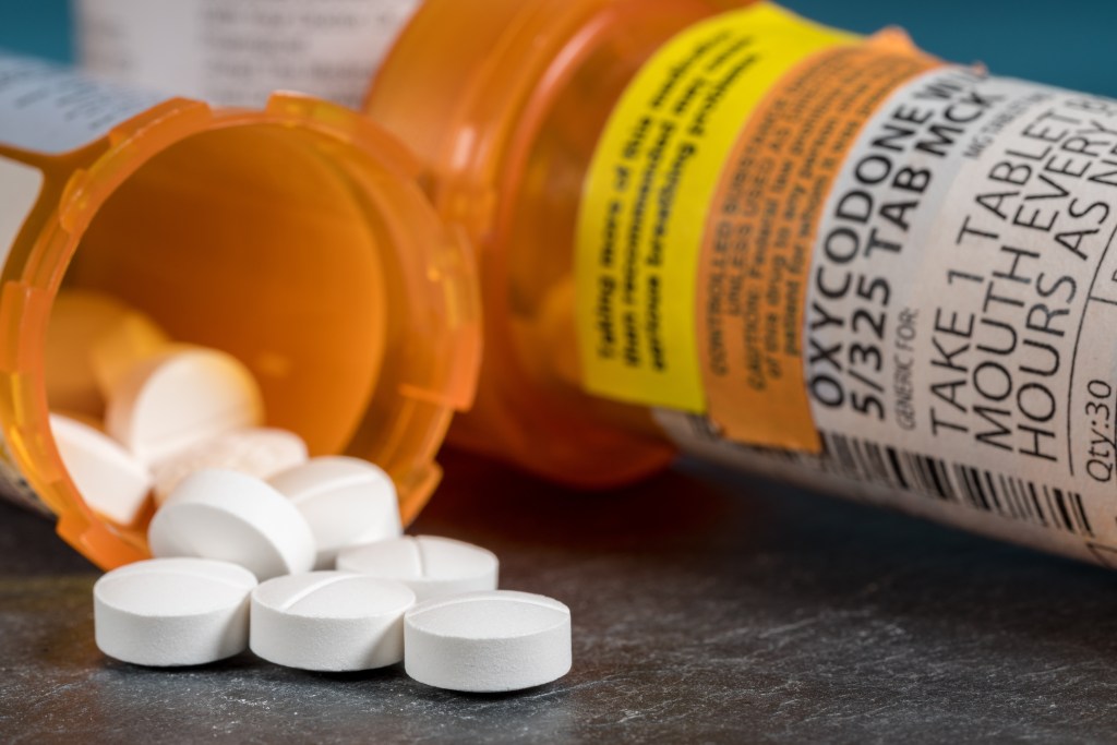Oxycodone tablets spilled from a prescription bottle.