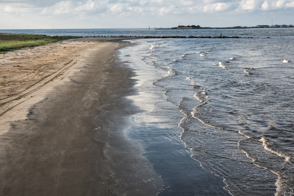 Beach at Grand Isle, Louisiana, with Fort Livingston ruins in the background.