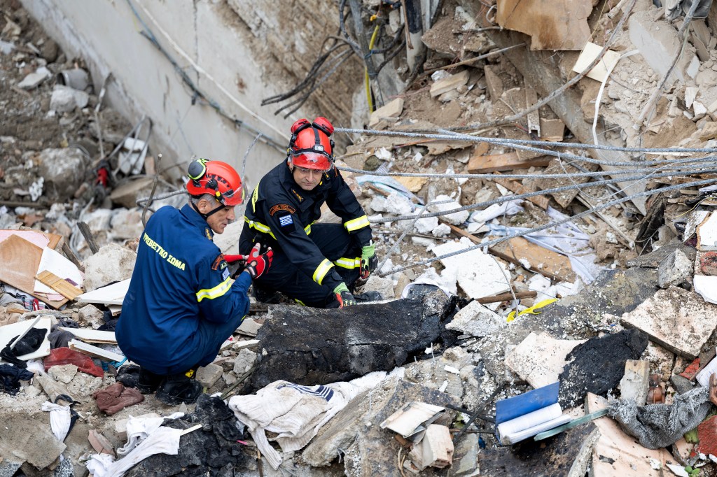 Firefighters work at the scene following Friday's powerful blast in Athens' Plaka district.