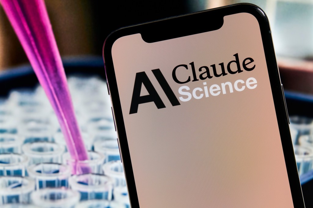 A photo illustration of a smartphone displaying the Claude Science logo in front of laboratory test tubes and a pipette with pink liquid.