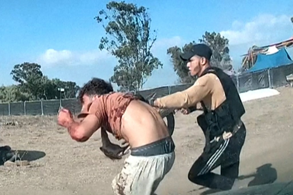 An armed Palestinian militant leads a man with a bloodied shirt during the Supernova music festival.