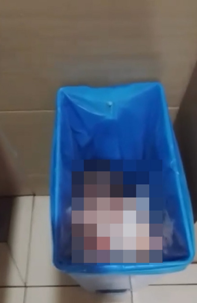 A newborn baby found alive in a sanitary bin lined with a blue plastic bag.