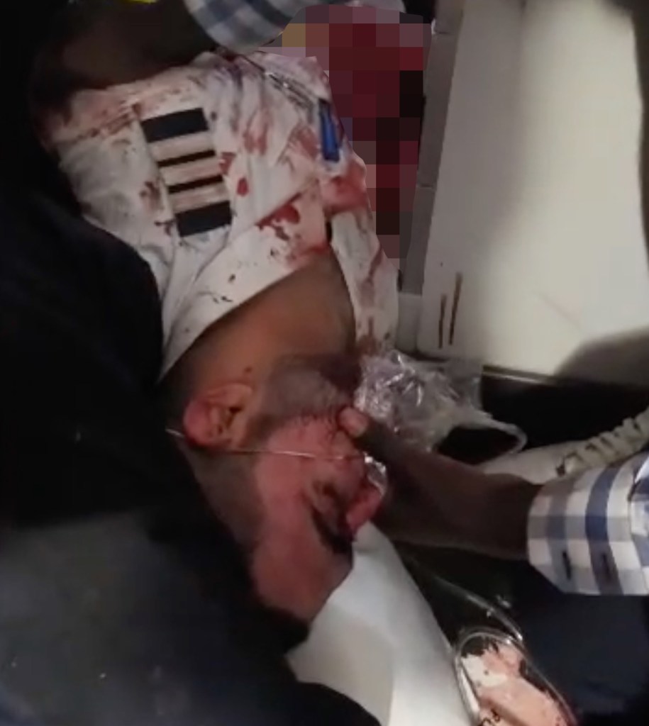 A pilot looks toward the camera while passengers assist him, and the co-pilot lies unconscious aboard Flydubai flight FZ1073.