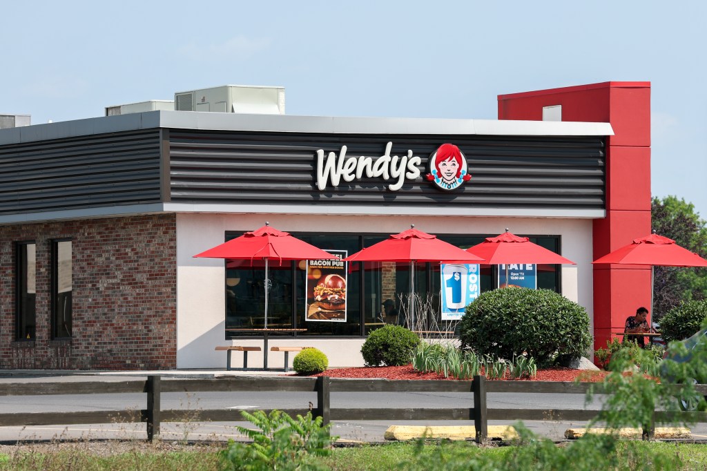 Wendy's logo on the facade of a fast-food restaurant.