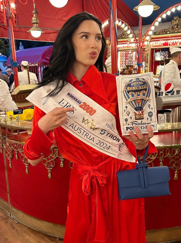 Lucia Sisic, Miss Austria 2024, wearing her sash and holding a bag of popcorn.