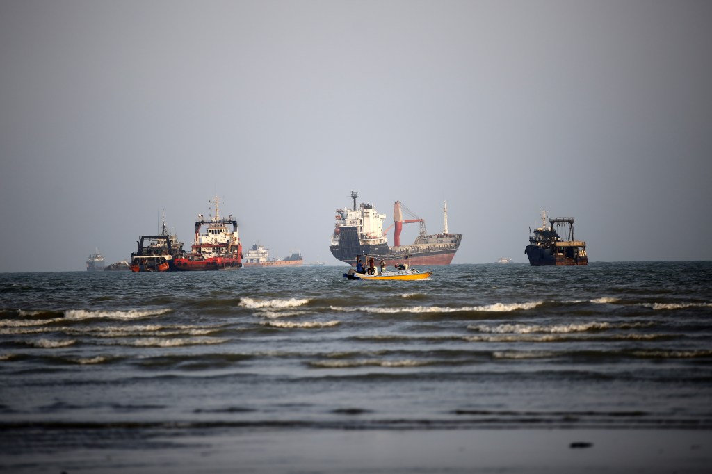 Various cargo ships and smaller boats in the water off the coast of Bandar Abbas, Iran.