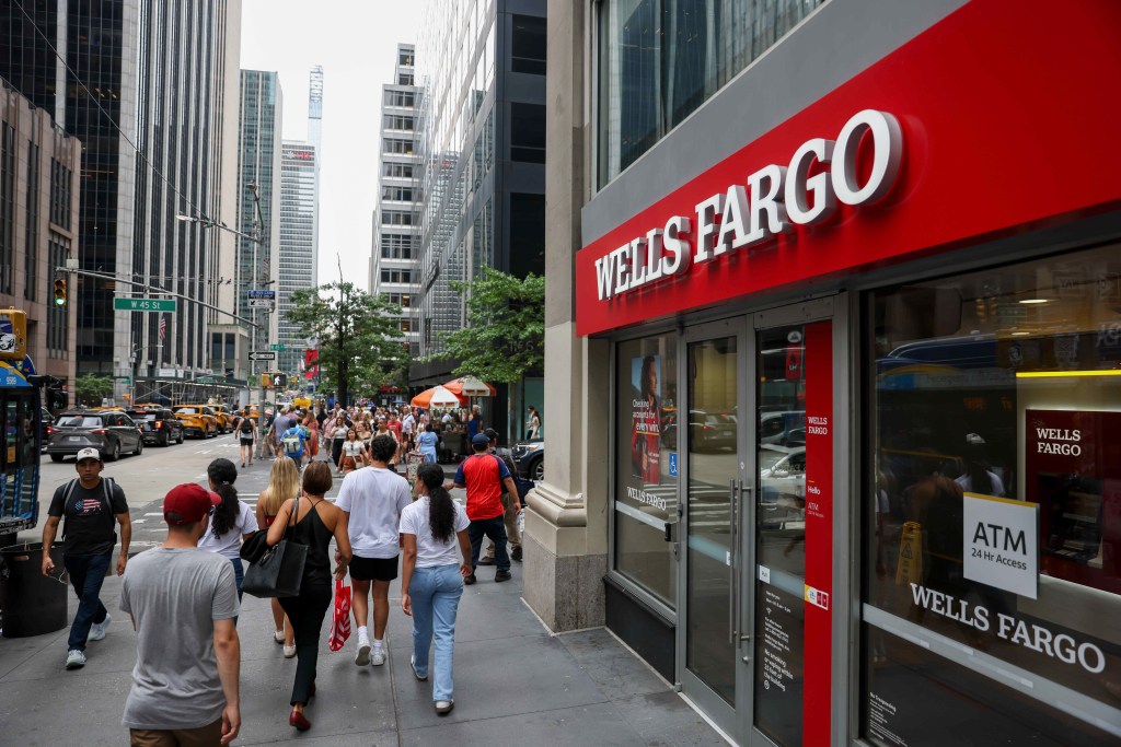 A Wells Fargo bank branch with its prominent red sign and a busy street in New York City.