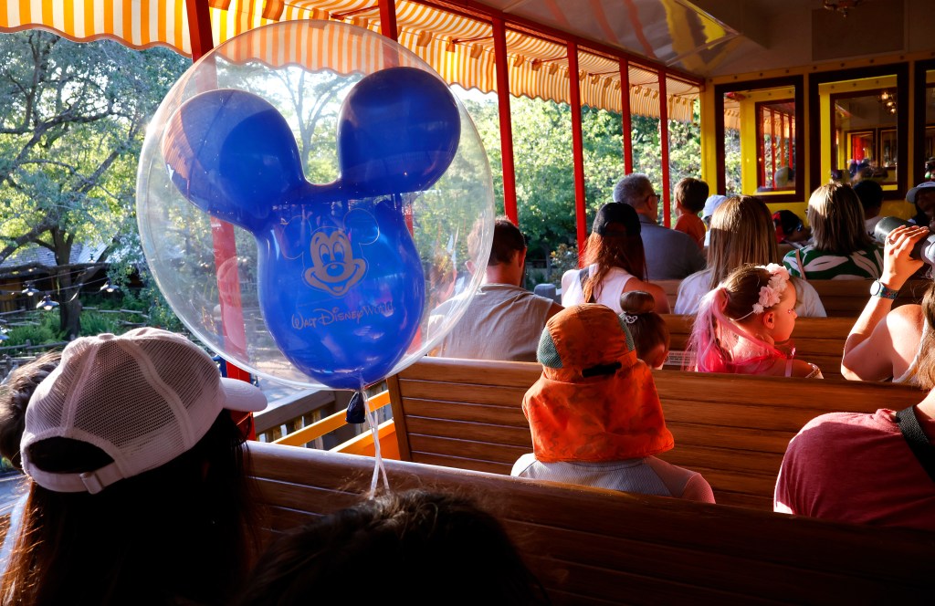 People ride on the Walt Disney World Railroad at the Magic Kingdom Park.