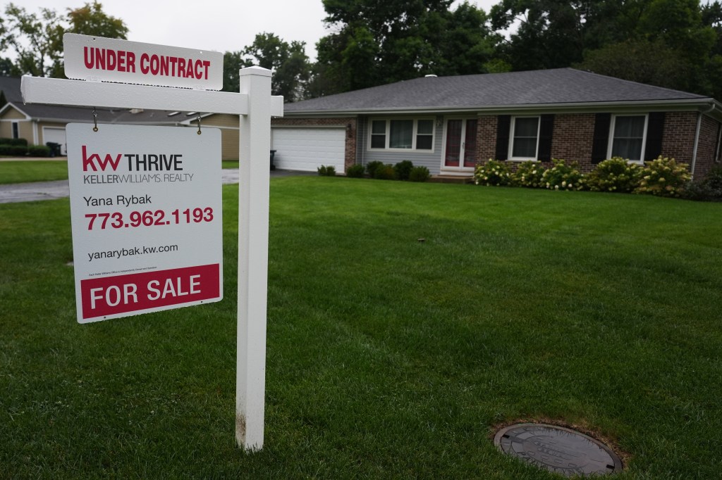 A for sale sign is displayed outside a home in Arlington Heights, Ill.