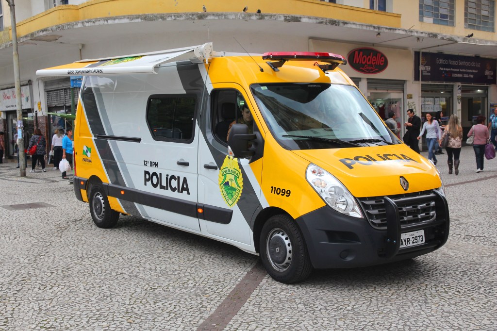 A military police van parked on a cobblestone street in Curitiba, Brazil.