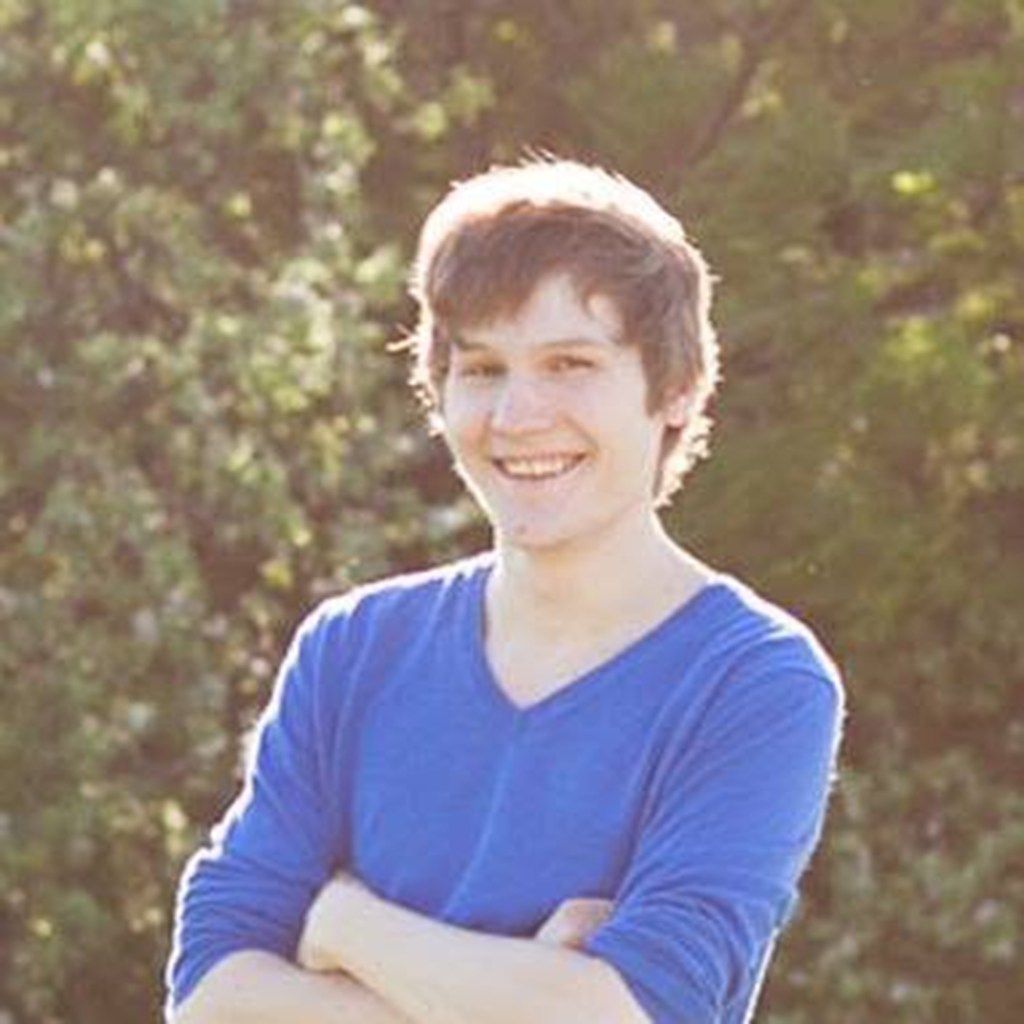 Manuel Otto smiling with arms crossed outdoors.