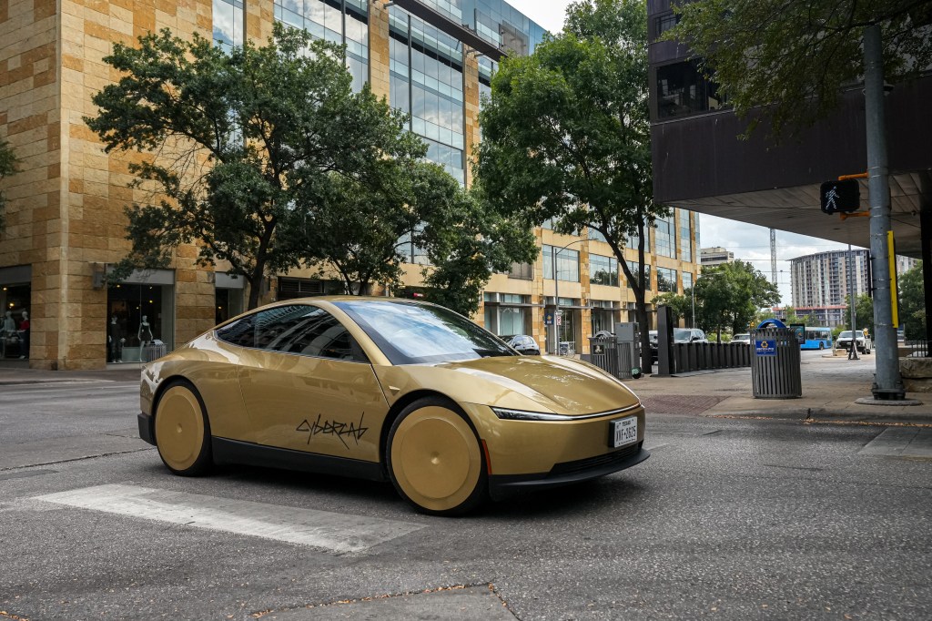 A golden Tesla Cybercab turns onto 2nd Street in Austin, Texas.