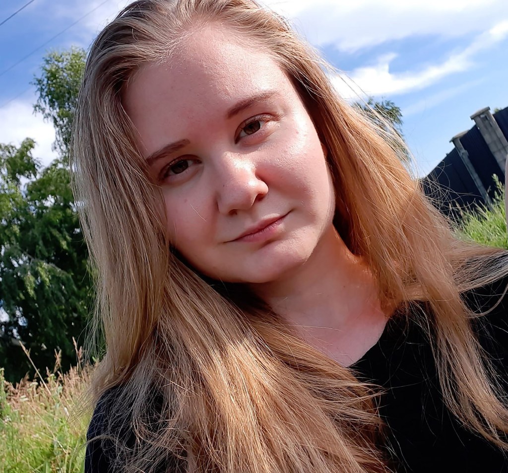 Portrait of Daria Shipilova outdoors under a blue sky.