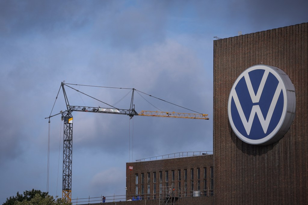 A construction crane stands next to the Volkswagen logo on the power plant at the Volkswagen headquarters in Wolfsburg, Germany.