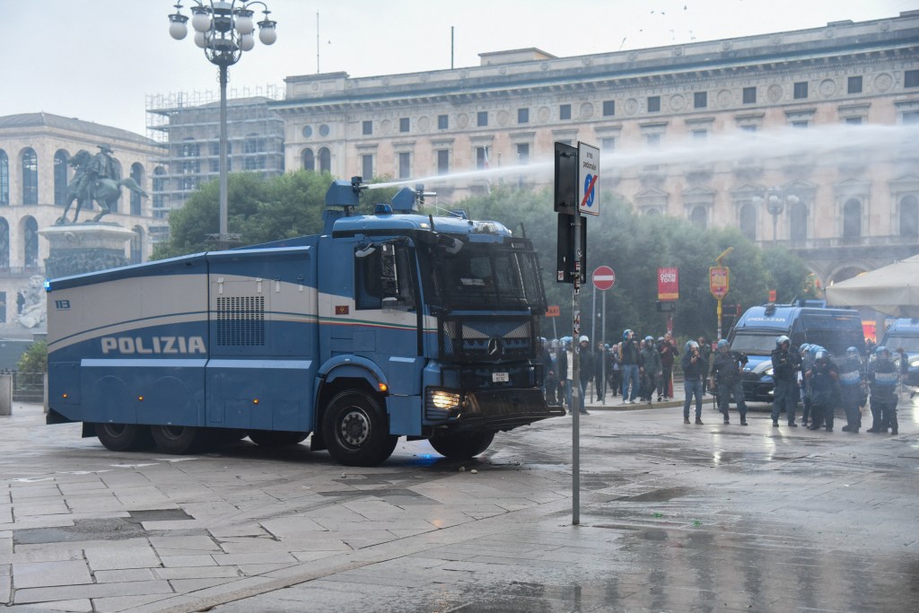 A police water cannon sprays a jet of water during a protest in Milan, Italy.