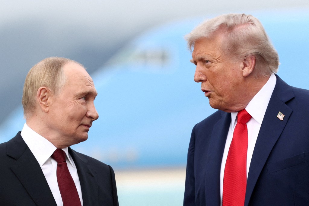U.S. President Donald Trump speaks with Russian President Vladimir Putin during a meeting.